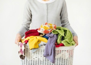 Woman holding a hamper with dirty laundry.