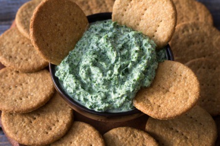 Spinach Dip surrounded by crackers.