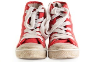 Scuffed pair of red canvas high top tennis shoes.