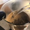 Adding hot water to the coffee grounds in the French press.