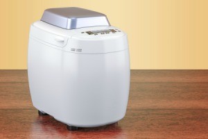 Clean white bread machine on wooden counter.