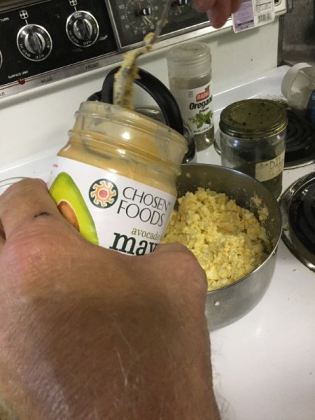 adding mayonnaise to eggs
