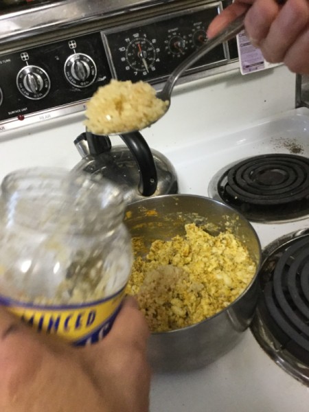 adding garlic to eggs