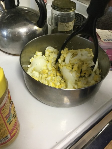 mashing hard boiled eggs in bowl