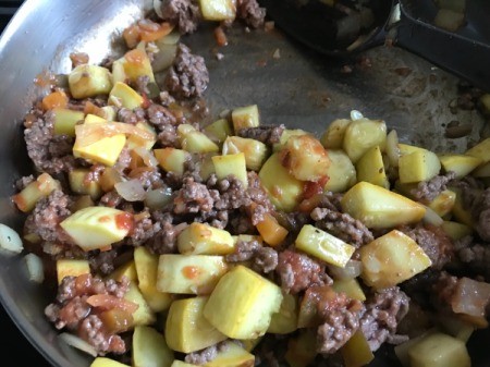 adding spices and tomato paste to stir fry