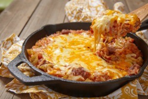 Cheesy beef casserole in a cast iron pan.