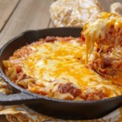 Cheesy beef casserole in a cast iron pan.