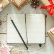 Notebook with wish list surrounded by gifts.