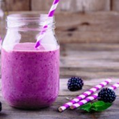 Blackberry Smoothie in a jar with fresh blackberries on the table.