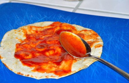 spreading sauce on tortilla
