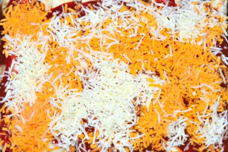 Covering Enchiladas with sauce and cheese