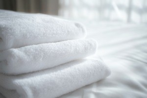 Folded white towels on a white sheet.