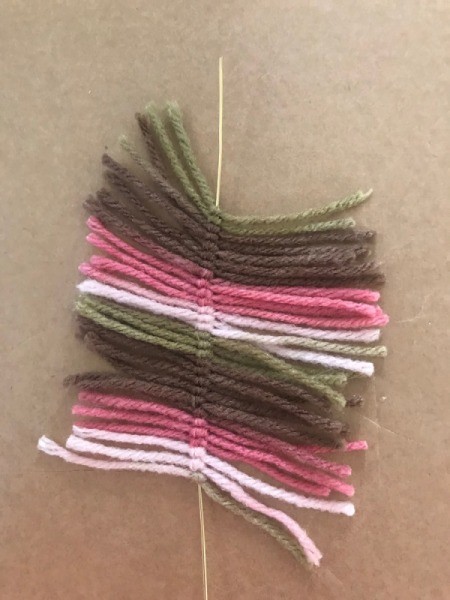 Recycled Cardboard Ring and Yarn Dreamcatcher - straight piece of wire with knotted lengths of yarn prior to trimming