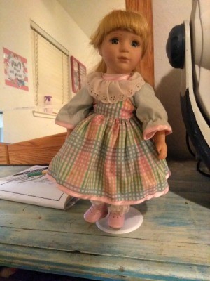 Identifying a Porcelain Doll - doll wearing a pink and blue gingham dress