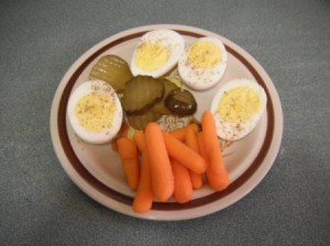 plate with deviled eggs carrots and pickles