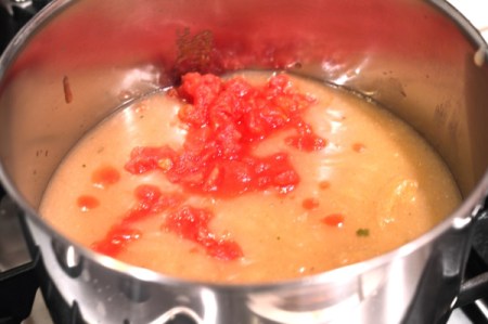 adding tomatoes to sauce