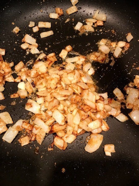 browned onions and seasoning in pan