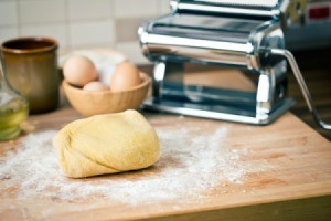 Ball of noodle dough on a floured surface.