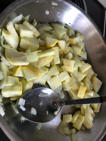 adding squash to onions in pan