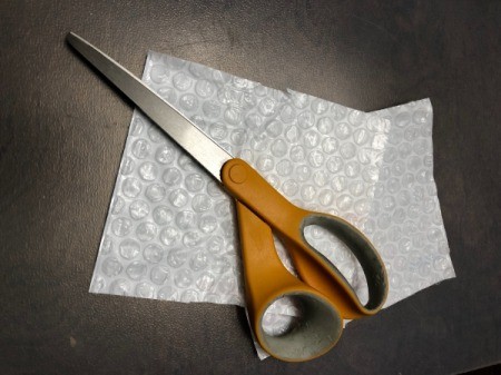 Wrapping Paper and Bow Made from Packaging Items - bubble wrap and scissors