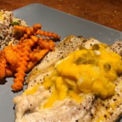 Baked Fish with Mango Jalapeno Relish on dinner plate