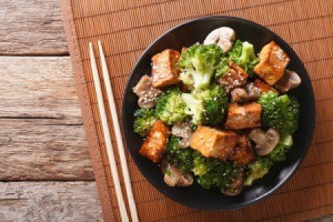 Tofu and broccoli with sesame seed in a bowl.
