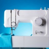White sewing machine with a piece of blue fabric.