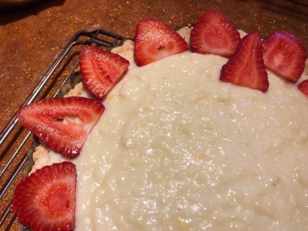 arranging sliced strawberries on dough