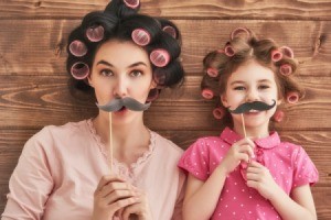 Mother and daughter with rollers and fake mustaches.