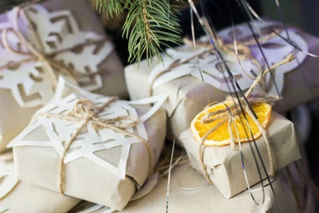 Butcher paper wrapped gifts embellished with paper snowflakes and dried orange slices.