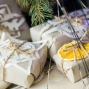 Butcher paper wrapped gifts embellished with paper snowflakes and dried orange slices.