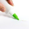Hand squeezing glue onto a white paper.