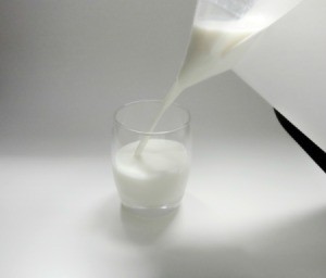 Pouring milk from a bag of milk in a pitcher.