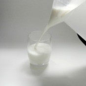 Pouring milk from a bag of milk in a pitcher.