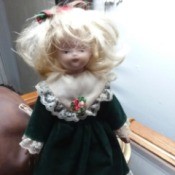 Identifying a Porcelain Doll - doll wearing a dark blue dress with lace at bottom and sleeves
