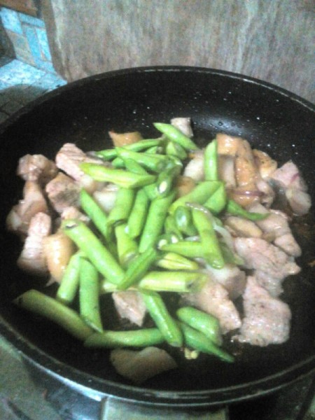 adding green beans to pork