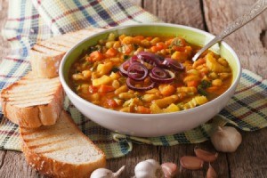 A bowl of Italian soup with slices of bread.