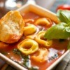Italian Tortellini Soup with a piece of bread.