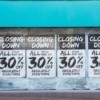 30% closing sale signs in a store window.