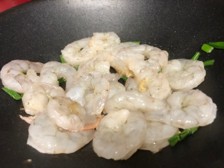 Shrimp added to green onions and garlic