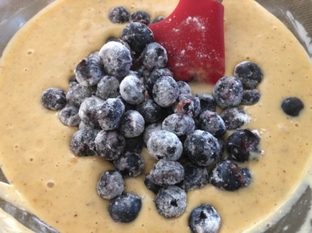 adding floured blueberries to batter
