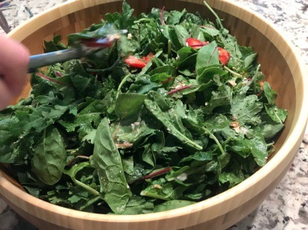 mixing salad with dressing