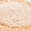 Close up of a tan injera sponge texture.