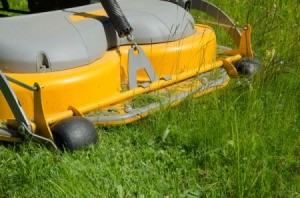 Close up of riding lawnmower cutting grass.