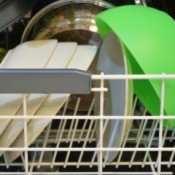 Green plastic bowl in a dishwasher.
