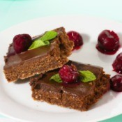 Pieces of fudge on a plate with cherries.