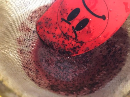 DIY Organic Food Colouring - pushing blueberries through the sieve
