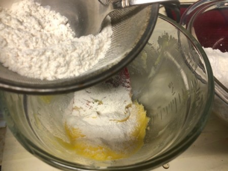 adding flour to batter