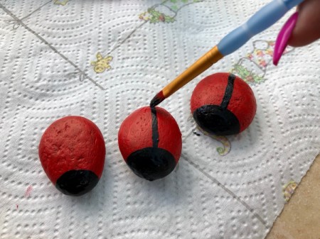 Stone Ladybug Garden Ornaments - paint a black line from the face to the other end