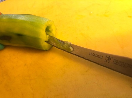 cleaning inside of cucumber with knife